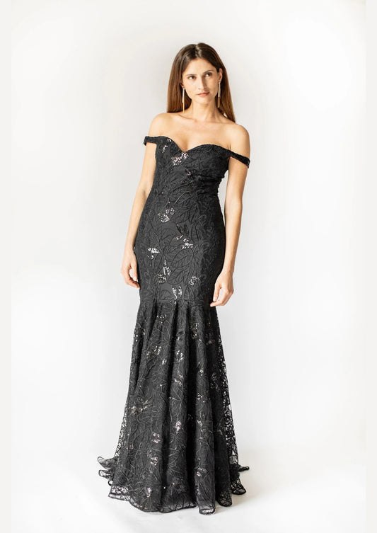 Woman wearing a black lace evening gown against a white background